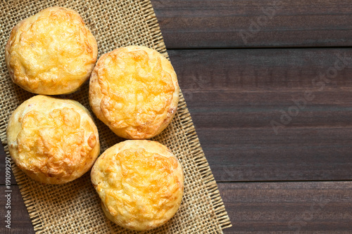 Hungarian traditional Cheese Pogacsa savory baked bread-like pastry, photographed overhead on dark wood with natural light (Selective Focus, Focus on the top of the pastries)