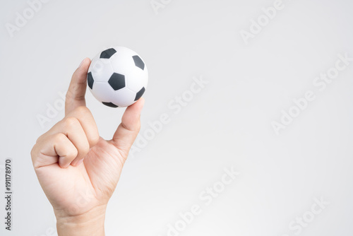 Hand holding small soccer ball or football