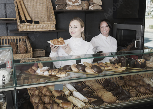 Happy women with desserts in the pastry shop