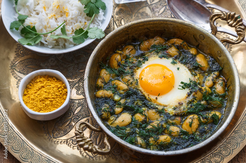 Persian breakfast with eggs, bean and dill in copper pan