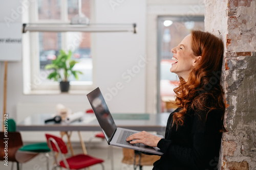 Young woman laughing at a good online joke