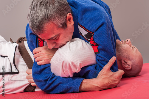 Brazylijski instruktor jiu jitsu demonstruje techniki blokowania ramion w walce w parterze