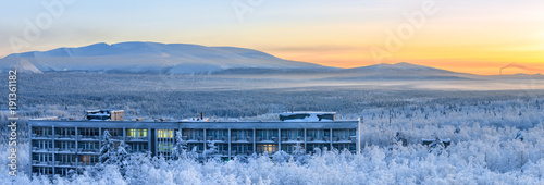 Winter panorama of the Khibiny (Hibiny) mountains during the sunrise. Fog is spreading over the ground. Apatity, Kola Peninsula, Murmansk region, Russia.