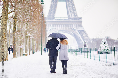 Couple of tourists walking in Paris on a day with heavy snow