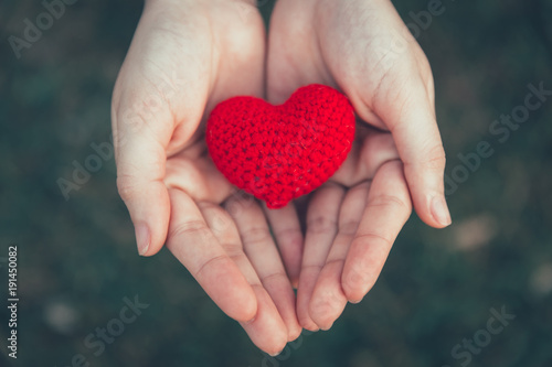 Sharing Love and Heart red color on women hand in valentine's day vintage color tone