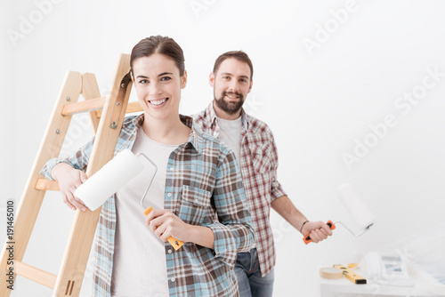 Happy couple painting their new home