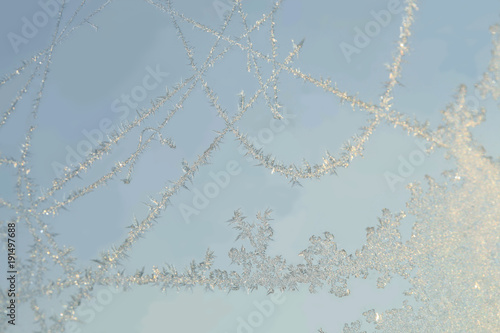 Ice patterns on the window during strong frost. Flowers, lines, crystals, ice rose, abstract pattern