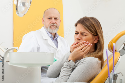 Female patient with toothache at the dentist office