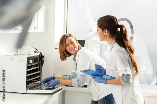 Female dentists in dental office .They cleans equipment for next working day.Using autoclave.