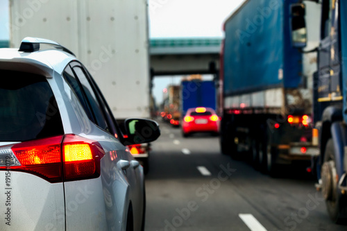 Intense traffic flow of trucks and cars. Jam on the highway. Road repair works. Rear view.