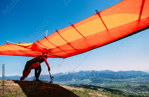 Człowiek z lotnią zaczyna latać ze szczytu wzgórza