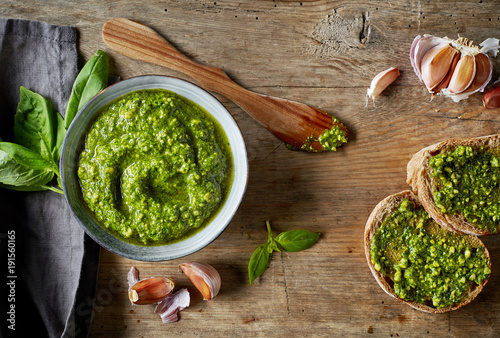 Bowl of basil pesto on wooden table