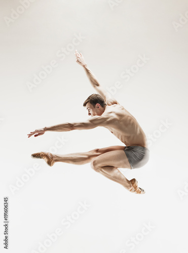 The male athletic ballet dancer performing dance isolated on white background.