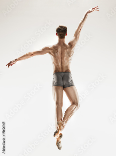 The male athletic ballet dancer performing dance isolated on white background.