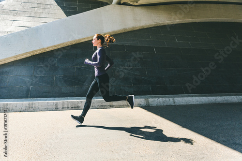 Woman jogging or running, side view with shadow