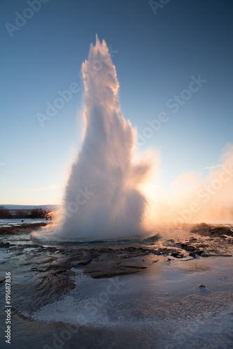 Strokkur Geysir geyser on the south west Iceland. Famous tourist attraction Geysir on route 35 in sunrise. High eruption of boiling water at geothermal area Haukadalur. Water fountain in winter.
