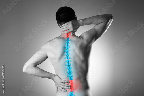 Pain in the spine, a man with backache, injury in the human back and neck
