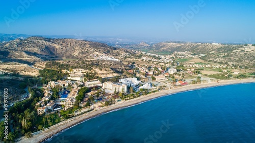 Aerial bird's eye view of Pissouri bay, a village settlement between Limassol and Paphos in Cyprus. Panoramic view of the coast, beach, hotel, resort, hills, plain and building developments from above