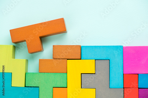 Different colorful shapes wooden blocks on blue background, flat lay. Geometric shapes in different colors, top view. Concept of creative, logical thinking or problem solving. Copy space.