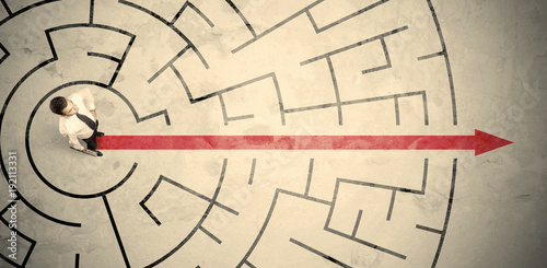 Business person standing in the middle of a circular maze