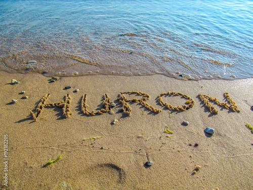 Hand drawn word on sandy beach at Lake Huron. Close up detailed image of sand, text and lake water.