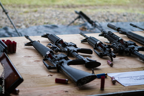 A table with multiple assault rifles