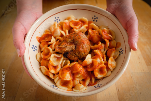 Typical Apulia region Sunday main course: fresh pasta orecchietta and meat roll braciola with tomato sauce