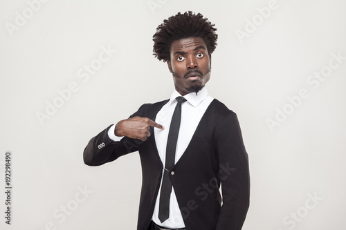 Amazement aloof afro man looking at camera. Studio shot, gray background