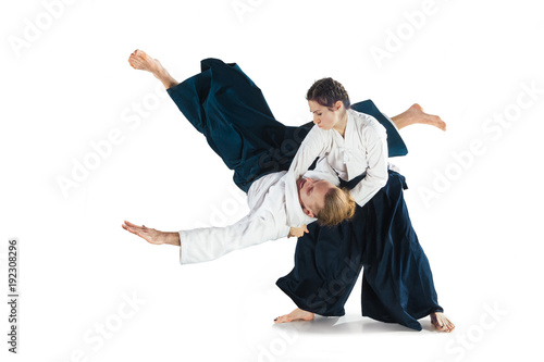 Man and woman fighting at Aikido training in martial arts school