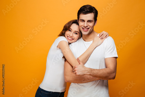 Pleased lovely couple posing together and hugging