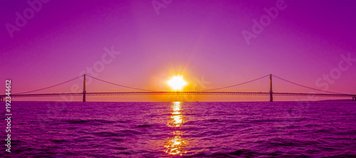 Sunset view and Mackinac Bridge in Michigan, USA. This is a long steel suspension bridge located in the Great lakes region and one of the most famous landmarks of North America.