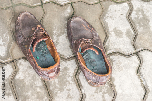 pair of old brown leather shoes on cement background