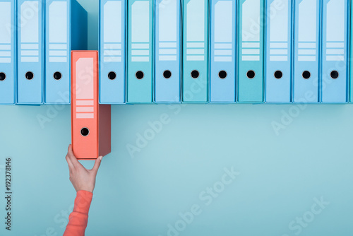 Office worker taking a folder in the archive