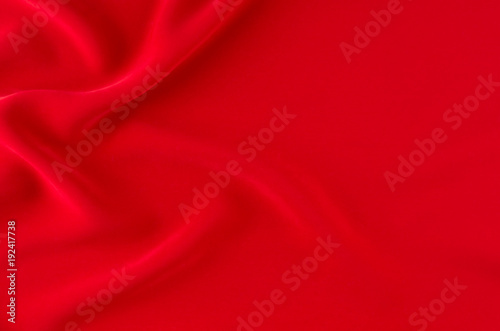 Deep red silk smooth wavy background with copy space.