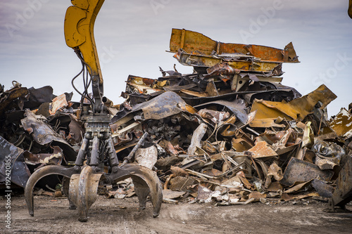 Large tracked excavator working a steel pile at a metal recycle yard