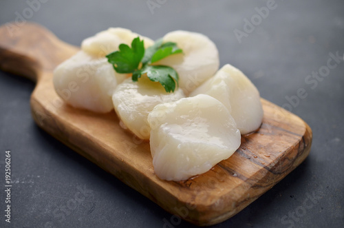 Raw scallops with herbs on cutting board