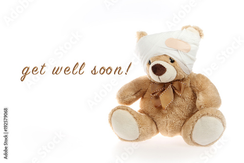 Teddybär mit verbundenem Kopf und dem Spruch "get well soon" nebenstehend