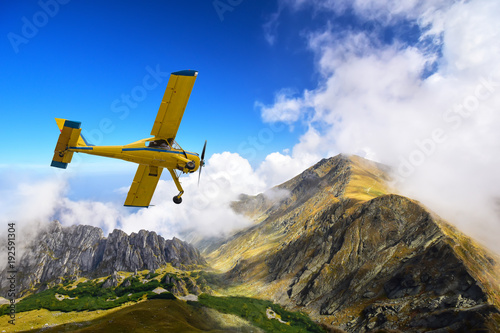Old and vintage cessna plane flying above Carpathian mountain peaks in Romania
