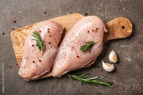 Fresh chicken fillet with spices on cutting board