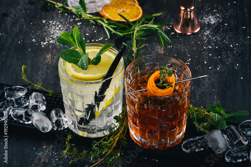 Two Alcoholic Cocktail Gin and Tonic, Negroni. On a black wooden background.