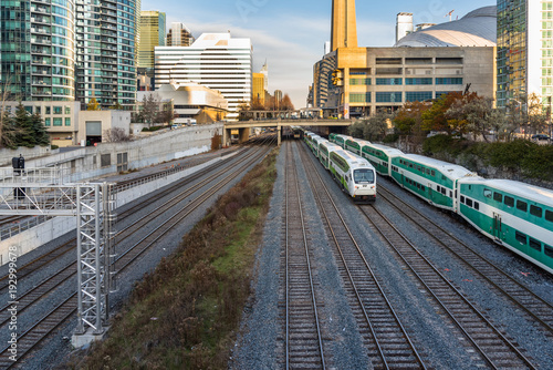 Passenger Trains on Parallel Tracks near a Station in Downtown Toronto on a Winter Day