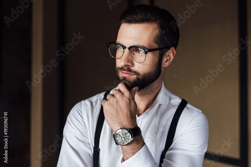 fashionable thoughtful man in trendy eyeglasses
