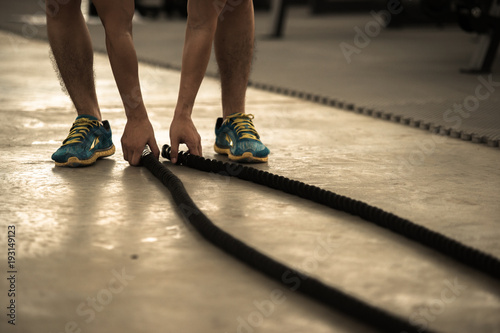 Fitness trainner show how to play the sport rope equipment in the gym
