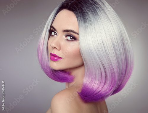 Bob hairstyle. Colored Ombre hair extensions. Beauty Model Girl blonde with short purple hair style isolated on gray background. Closeup woman portrait.