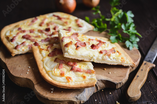 Traditional Tarte flambée with crème fraiche, cheese, onion and bacon