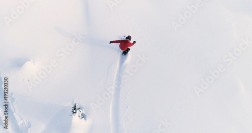 Snowboard widok z góry na dół na snowboardzistę jadącego przez świeży proszek Snow Down Ski Resort lub stok backcountry - tło sportów ekstremalnych
