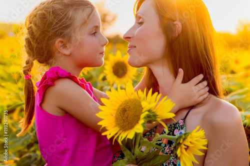 Little girl surprising mom with sunflowers at Mother's Day