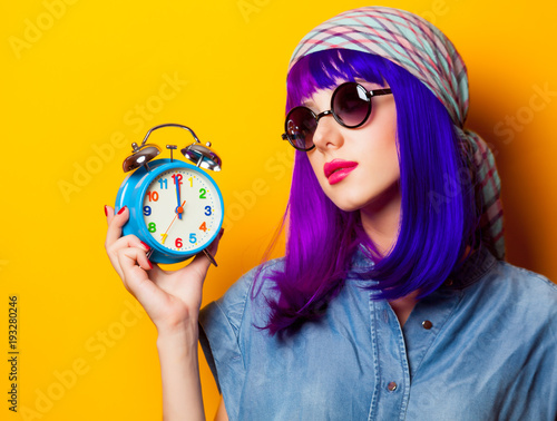 Young girl with purple hair and alarm clock