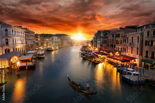 Romantischer Sonnenuntergang über dem Canal Grande in Venedig mit vorbeifahrender Gondel