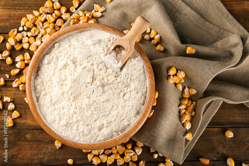 Bowl with corn starch and kernels on table